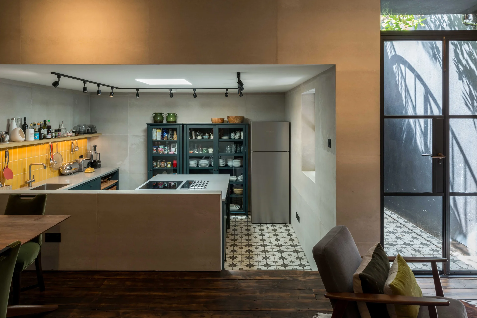 Modern kitchen with energy-efficient lighting, reclaimed wood flooring, and a view of a compact, efficient cooking space with exposed shelving and tiled backsplash.
