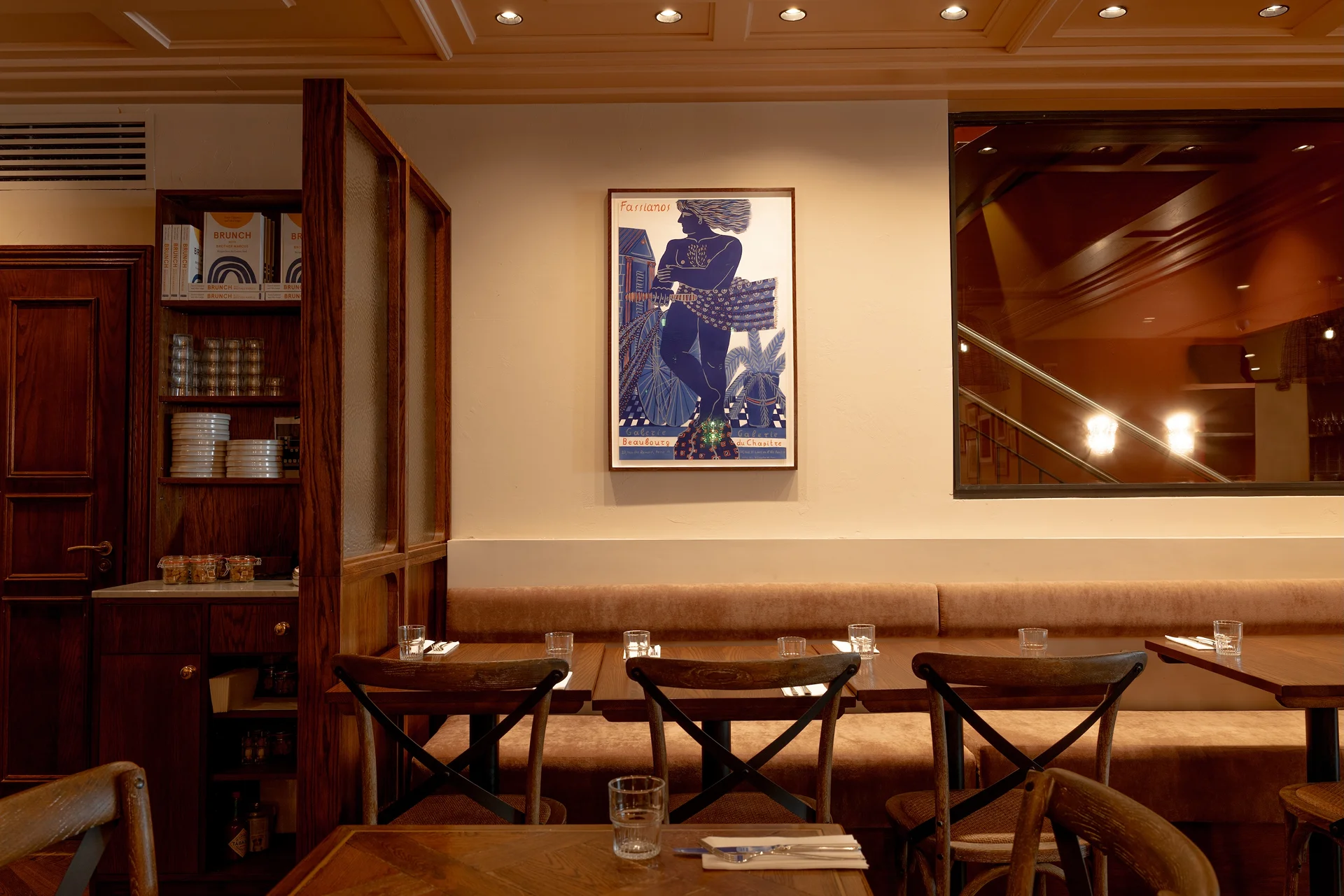 A cozy restaurant interior featuring wooden furniture and a framed artwork on the wall.